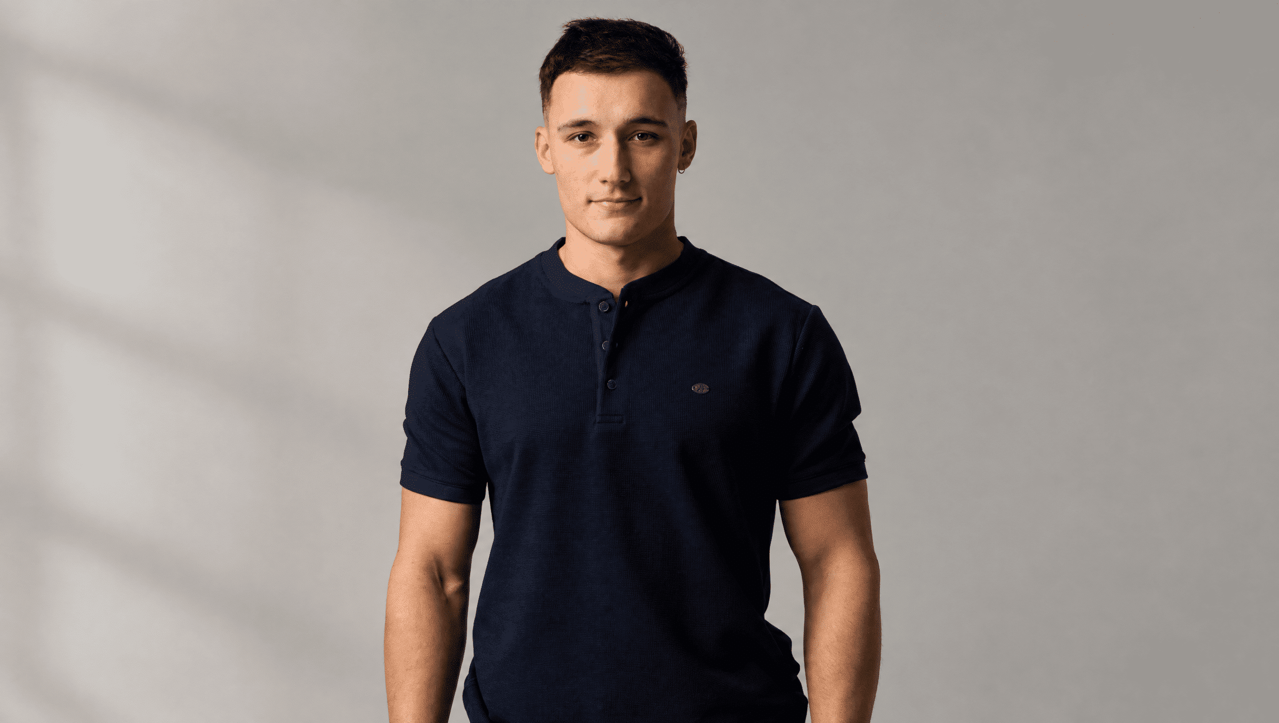 Model SHUBA WEAR w granatowej koszulce męskiej z guzikami pod szyją